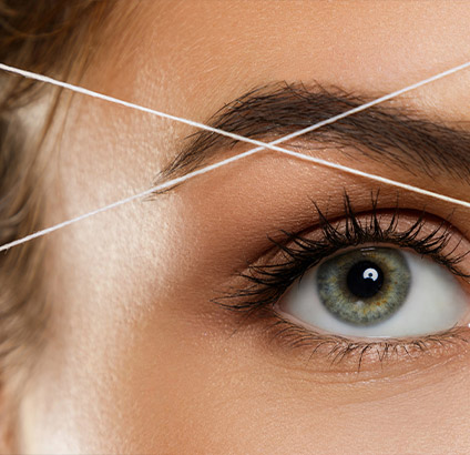 Epilation aux fils des sourcils et restructuration des sourcils